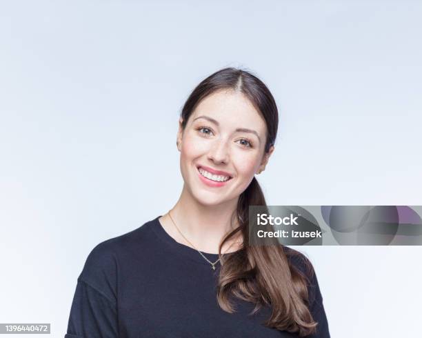 Happy Young Woman Against White Background Stock Photo - Download Image Now - Formal Portrait, Smiling, White Background