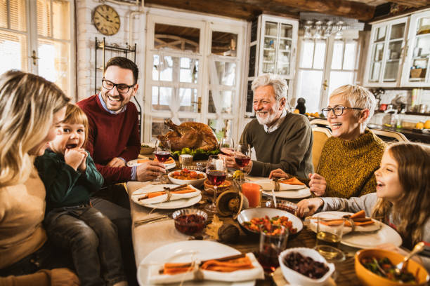 istock Happy multi-generation family communicating while having Thanksgiving lunch in dining room. 1396440842