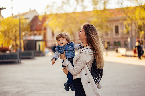 Male toddler having fun with his mom, enjoying outside, sunny day.