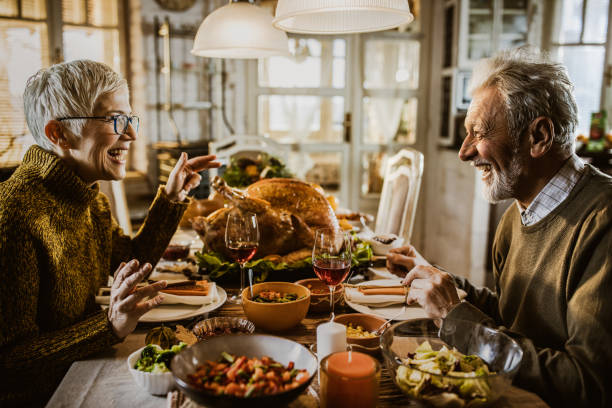 istock Happy senior couple talking on Thanksgiving lunch at dining table. 1396441887