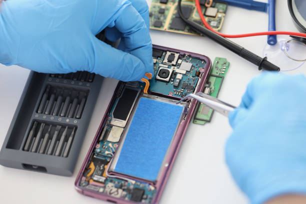 istock Technician fixing broken mobile phone, set new battery and cover, return old cellphone to life 1396442116