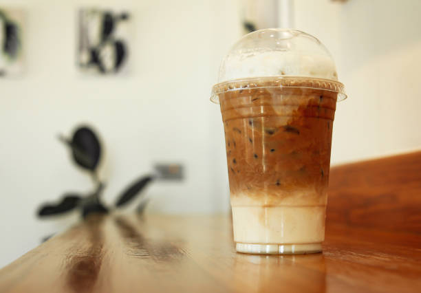 istock Coffee in a plastic cup on a wooden table in a cafe 1396442366