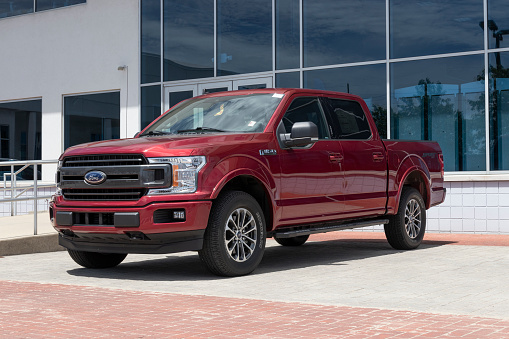 Fishers - Circa May 2022: Ford F-150 display at a dealership. The Ford F150 is available in XL, XLT, Lariat, King Ranch, Platinum, and Limited models.