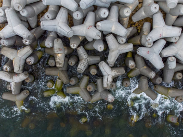 vista aerea drone di un frangiflutti. frangiflutti in mare, una collezione di frangiflutti in calcestruzzo - sea defence concrete foto e immagini stock