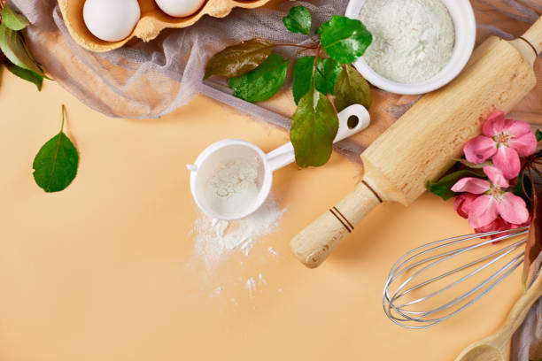 istock Bakery  or cooking frame with flower, ingredients, kitchen items for pastry on pastel orange background,  spring cooking theme. Top view, copy space. 1396444665