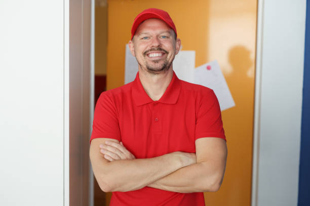 istock Happy man courier in red shirt and cap uniform, delivery worker 1396447904