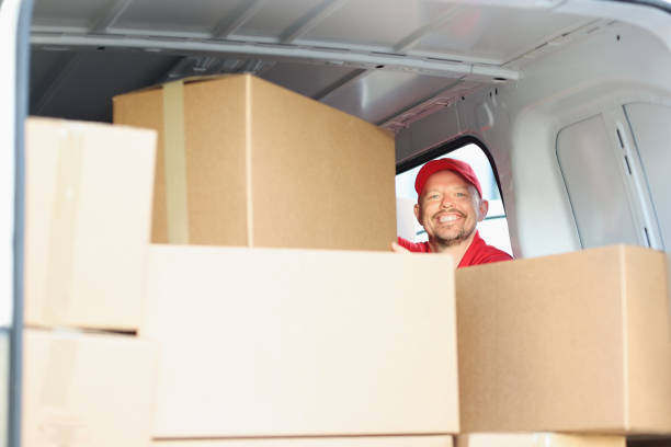 istock Happy smiling middle aged man on work, put cardboard boxes in truck for delivery 1396447964