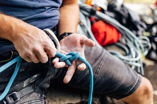 The man sets up all the climbing equipment on him.