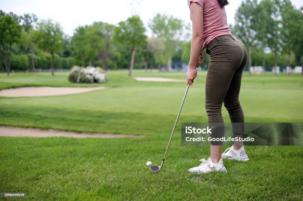 Putting Female golf player on a golf course. About 25 years old, Caucasian brunette. Golf Club Stock Photo