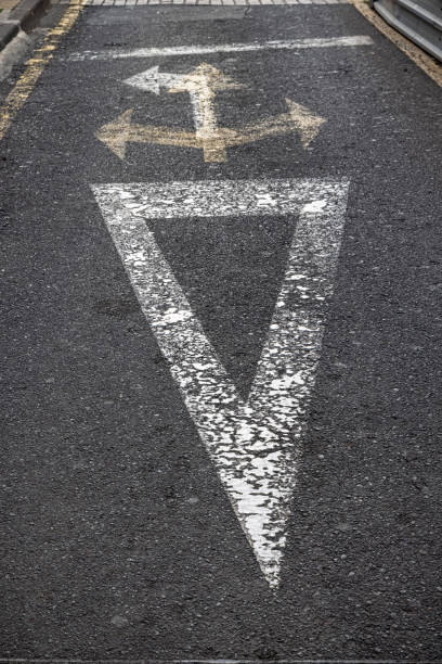 istock Worn and confusing arrows painted on a street 1396449587