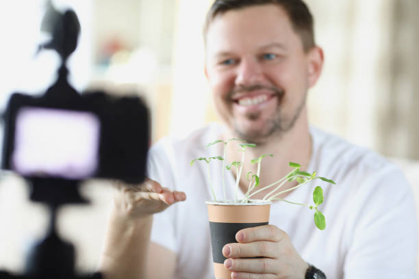 istock Middle aged man recording on video how he growing plants at home 1396450570