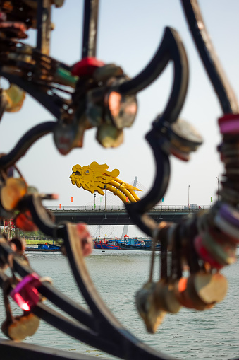 Dragon Bridge seen through the love locks in Danang city, Vietnam