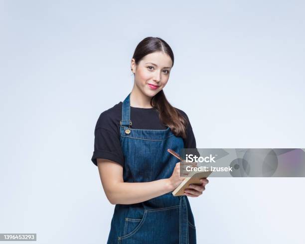Woman Writing On Note Pad Against White Background Stock Photo - Download Image Now - Note Pad, Barista, Cut Out