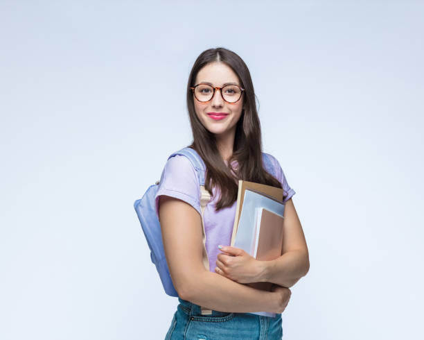 Beautiful woman with eyeglasses holding books stock photo