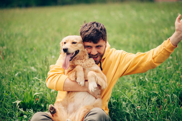 istock Guy and his dog, golden retriever, nature 1396455162