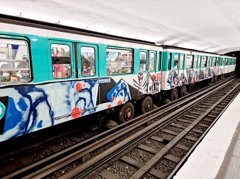 Paris Métro with an approaching train. The Metro wagon is covered by Graffities.