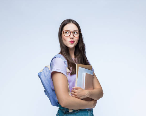 istock Woman with backpack holding books 1396455364