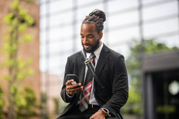 istock Young Male Office Worker With Dreads Scrolling On His Smart Phone 1396456951