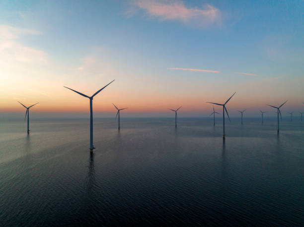 istock Wind turbines in an offshore wind park producing electricity during sunset. 1396460206