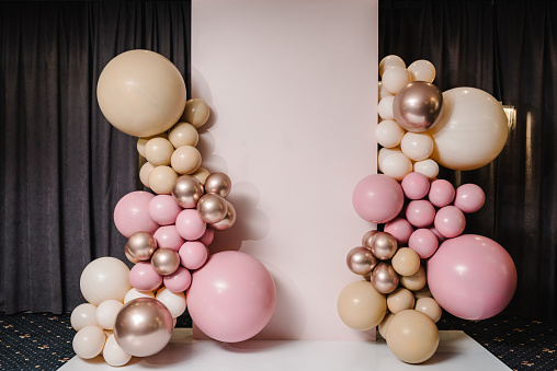 Wedding reception. Arch on background balloons, party decor. Photo-wall decoration space or place with pink, brown, and gold balloons. Trendy autumn decor. Celebration baptism concept. Birthday party.