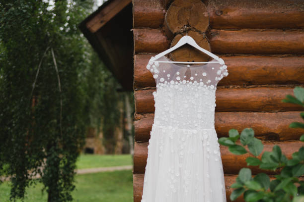 istock White wedding dress hanging on a tree outdoors in the garden. 1396462131