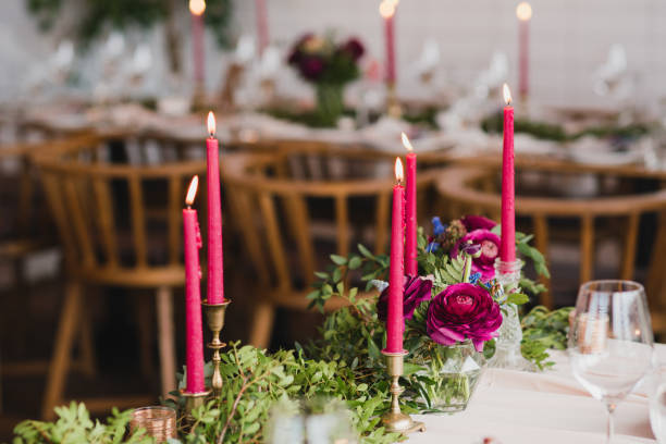 istock Table setting at the wedding reception. Floral compositions with beautiful ranunculus flowers and greenery, candles, laying and plates on a decorated table. 1396462265