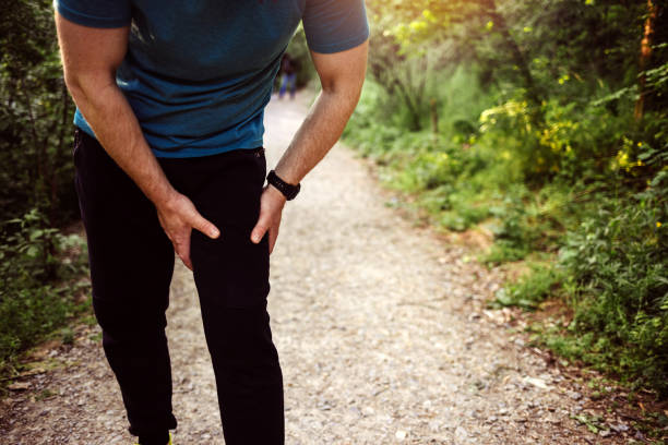 Young sport man with strong athletic legs holding knee with his hands in pain. Young adult male with muscle pain during running. Runner have leg ache due to groin pull. Sports injuries and medical concept. hugging knees stock pictures, royalty-free photos & images