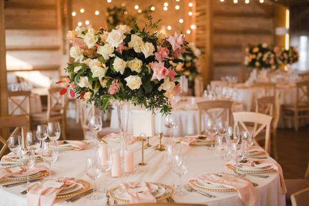 istock Table setting at the wedding reception. Floral compositions with beautiful flowers and greenery, candles, laying and plates on a decorated table. 1396463150