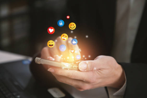 istock Young man using smartphone sending emojis. Mobile smartphone sending text messages emoji emoticon. 1396463286