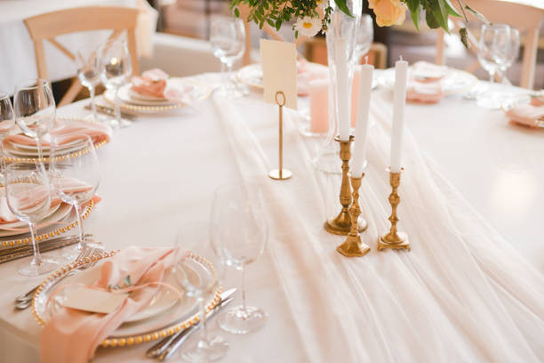 istock Table setting at the wedding reception. Floral compositions with beautiful flowers and greenery, candles, laying and plates on a decorated table. 1396463518