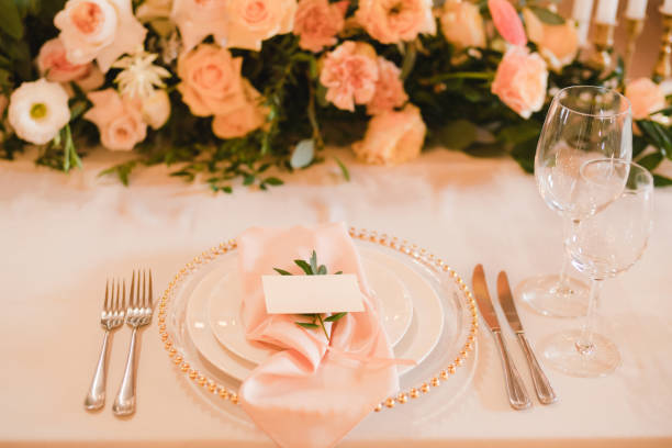 istock Table setting at the wedding reception. Floral compositions with name card on a vintage plate on a decorated table. 1396463631