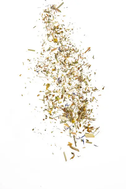 Photo of Scattered herbal tea with cammomile on a white isolated background