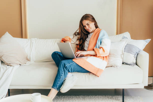 istock Young Caucasian female freelancer doing her work on laptop from home. 1396465381