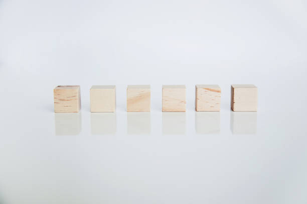 istock Wooden cubes arranged horizontally on white background with reflection. Conceptual and symbolic image. Copy space 1396466169