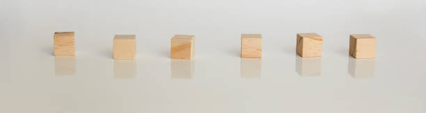 istock Wooden cubes arranged horizontally on white background with reflection. Conceptual and symbolic image. Copy space 1396466404