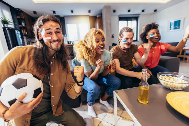 istock Young group watching sports on television and cheering. 1396466567