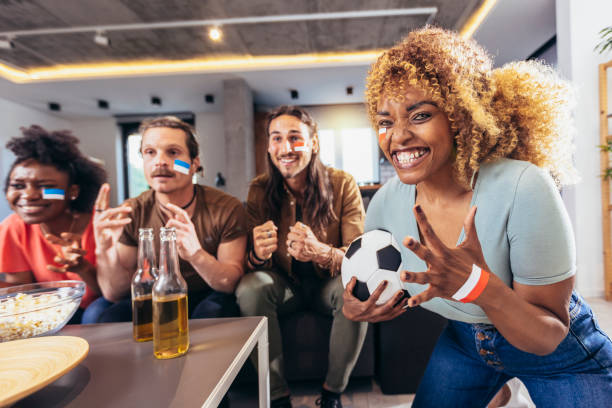 istock Young group watching sports on television and cheering. 1396466569