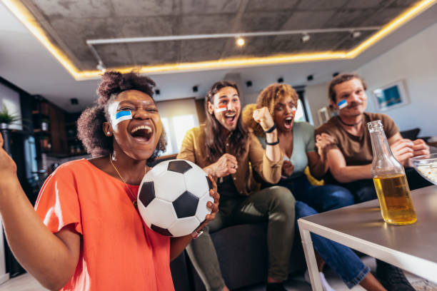 istock Young group watching sports on television and cheering. 1396466622