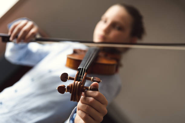 istock Teenage violinist tuning violin 1396467319