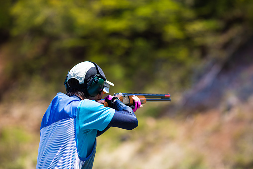 A Japanese sport shooter with a shotgun.