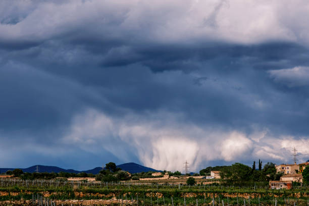 Sky full of clouds with a part falling to the ground as rain.