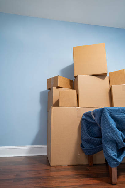 istock A stack of carboard moving boxes and a small table covered in a moving blanket 1396476174