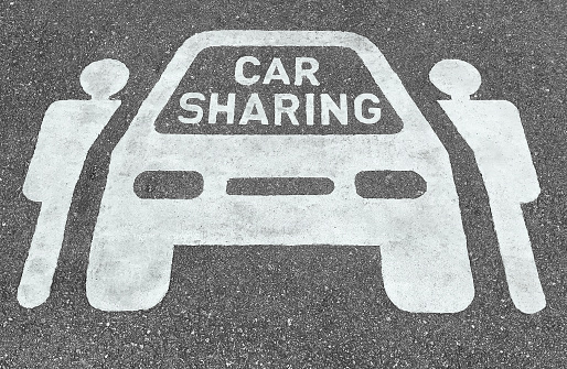 Car sharing parking symbols painted onto asphalt road. Car sharing service or rental concept. Sharing economy and collaborative consumption.