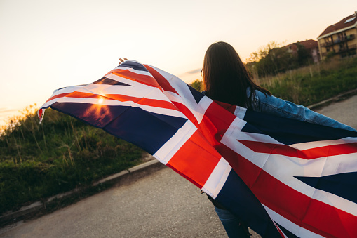 Woman spreading british flag outdoor.
