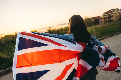 Woman spreading british flag outdoor.