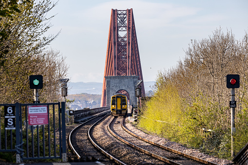 ScotRail Train at Southqueens Ferry Scotland crosses the Forth Rail Bridge.