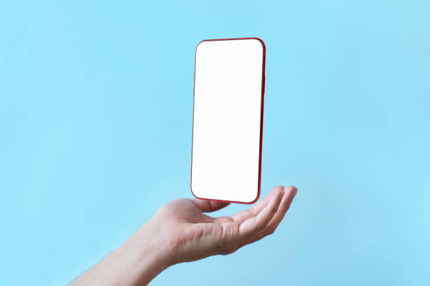 istock Smartphone floating in palm of hand supports with a blank display screen , Mobile phone isolate on blue green background 1396480313