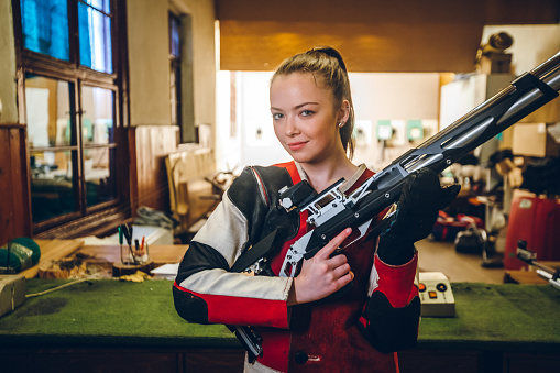 Young caucasian woman at sport shooter training.