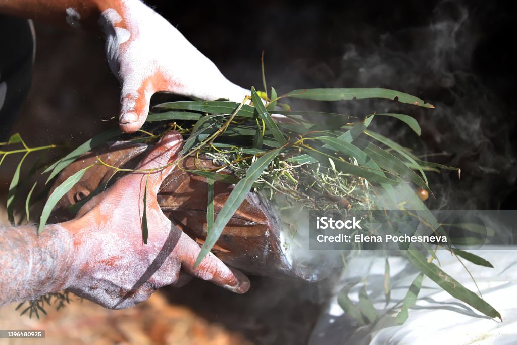Australian Aboriginal Ceremony, man hand with green eucalyptus branches and smoke, start a fire for a ritual rite at a community event in Adelaide, South Australia Aboriginal Peoples - Australia Stock Photo