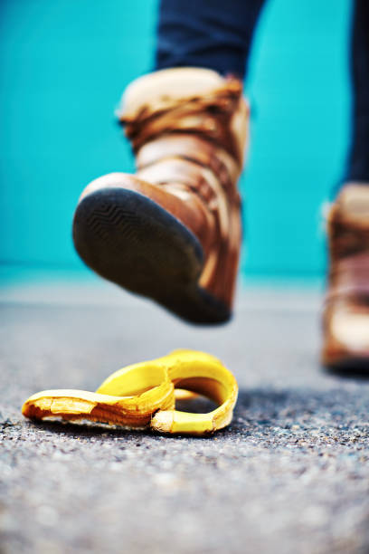 accident about to happen: foot stepping on a banana skin - sole of foot human foot women humor imagens e fotografias de stock